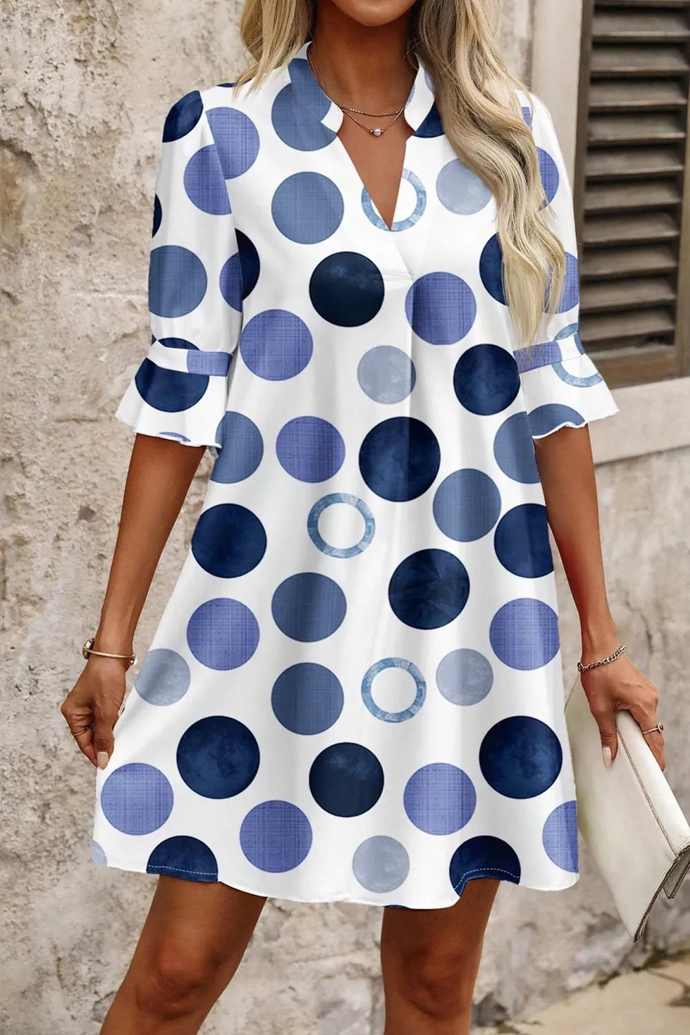 Woman wearing a polka dot dress with a neutral background