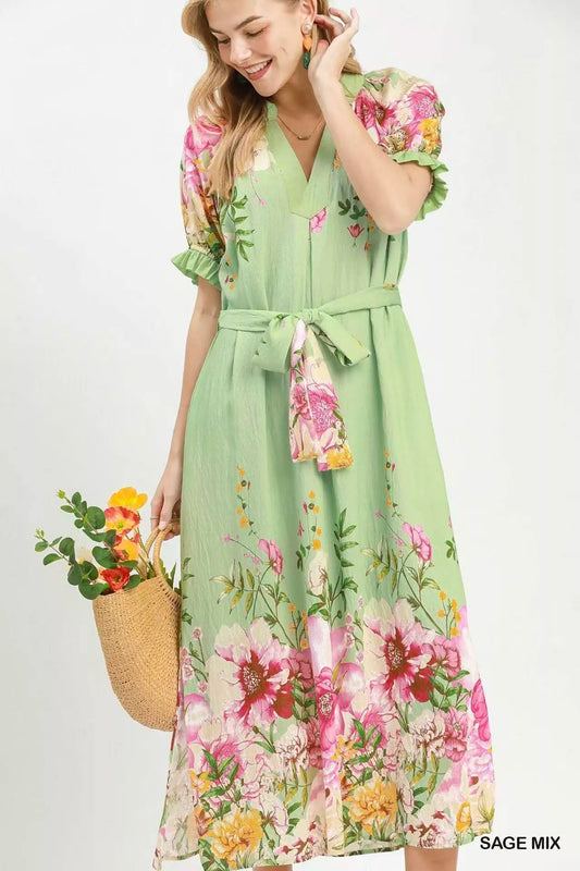 Woman wearing a green floral dress holding a straw bag with flowers on a white background