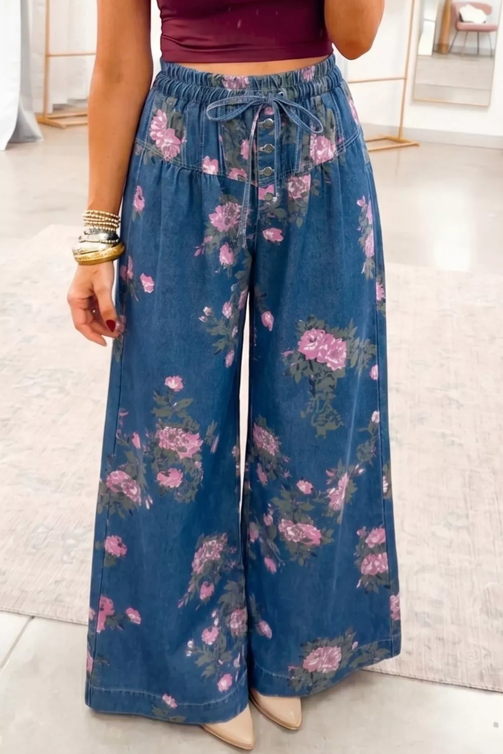 Person wearing blue floral wide-leg pants with a blurred background